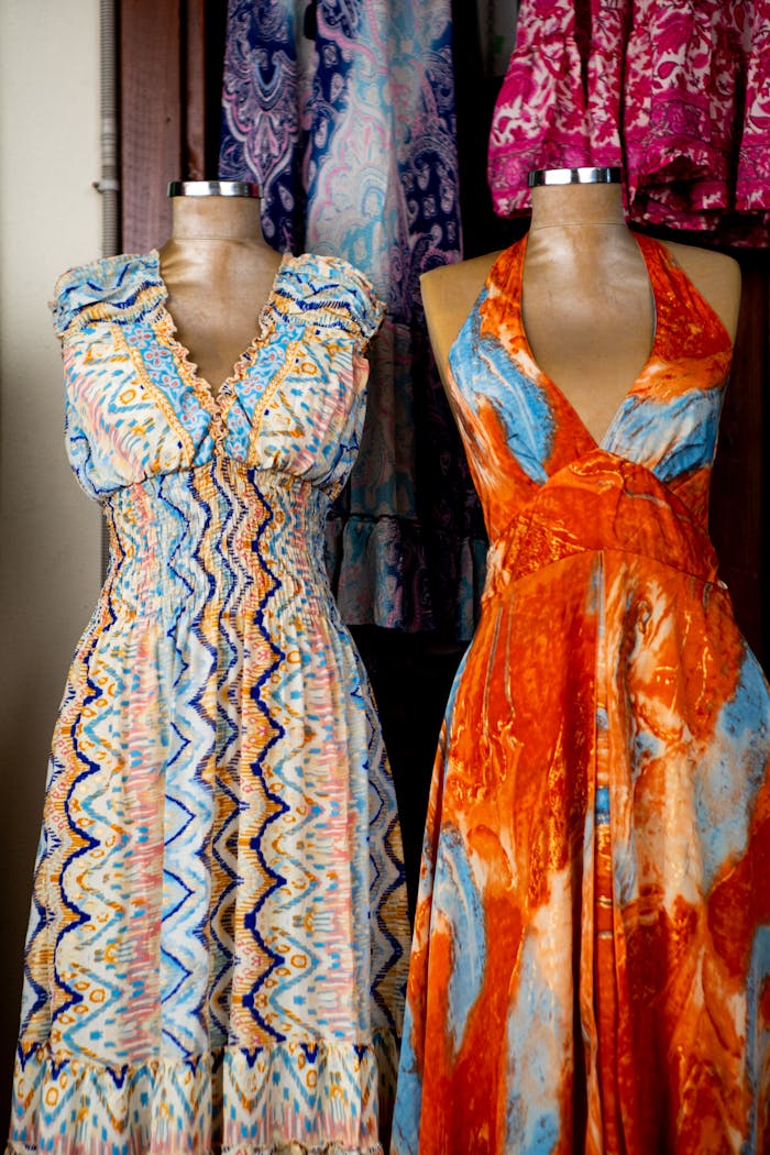 Vibrant summer dresses displayed on mannequins in a boutique setting.
