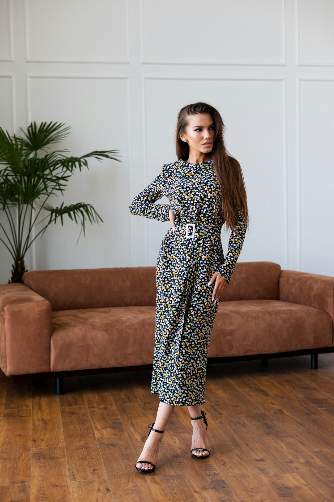 woman-in-black-and-white-floral-long-sleeve-dress-standing-beside-brown-couch-dpopc2vhuww